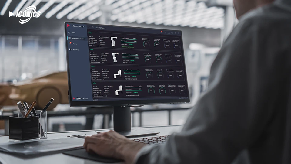 Photo of a man at a desk with four views of the Mitsubishi Electric robotic arm in various stages and associated dashboard metrics
